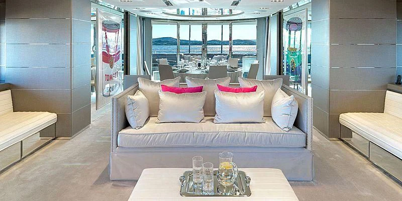 a couch with pillows and a table in a room with a window aboard BLISS Yacht for Sale