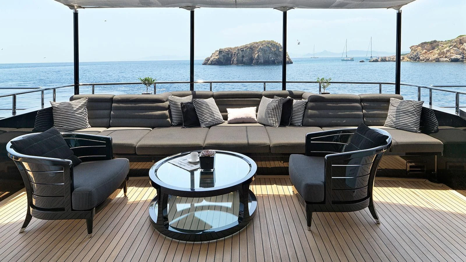 a couch and a table on a deck overlooking a body of water aboard BLISS Yacht for Sale