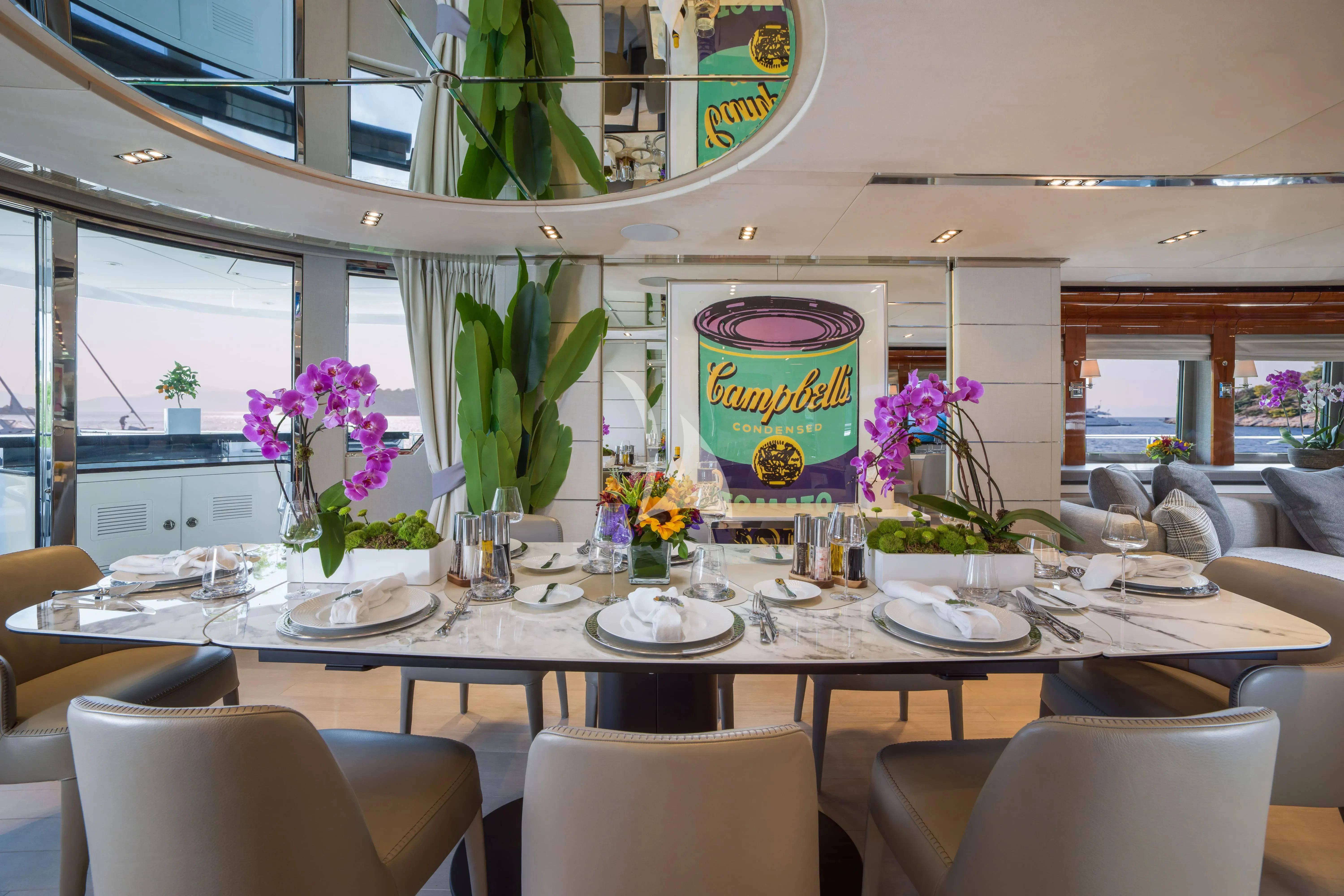 a table with plates and flowers aboard BLISS Yacht for Sale