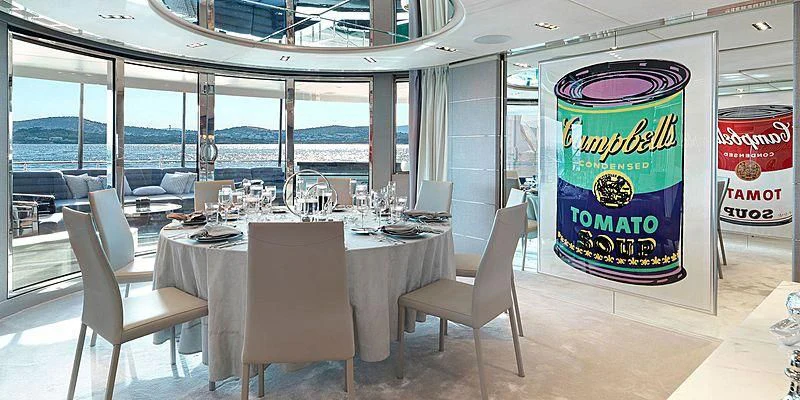 a table with chairs and a sign aboard BLISS Yacht for Sale