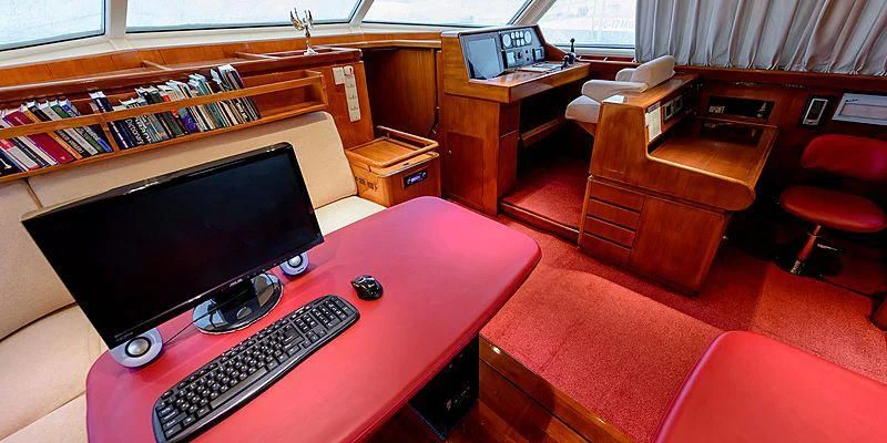 a red desk with a computer on it aboard SCORPIUS Yacht for Sale