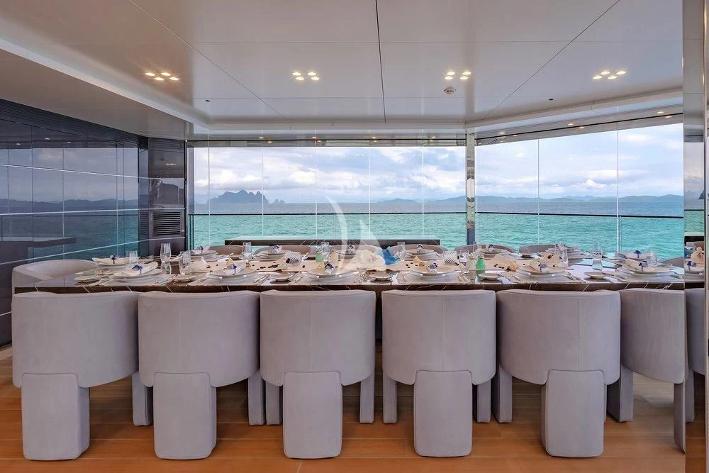 a row of white chairs in a room with a large window aboard WANDERLUST Yacht for Charter