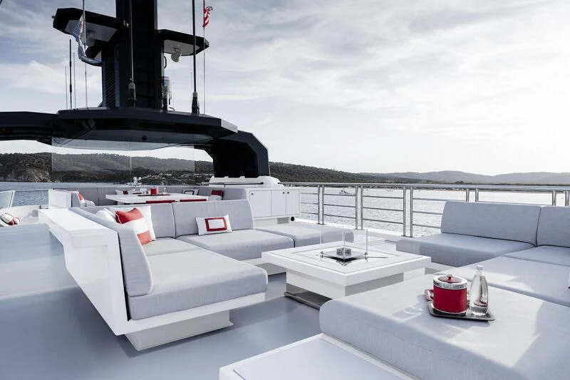 a white couch with a red and white pillow on it aboard WANDERLUST Yacht for Charter