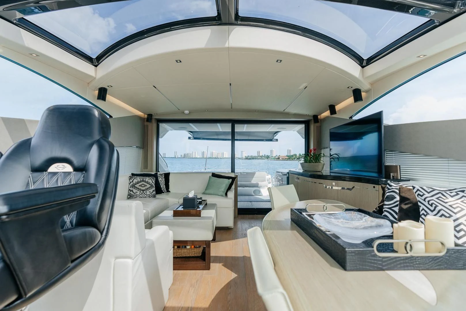 a room with a large window and a table with chairs and a tv aboard GRAVITAS Yacht for Charter