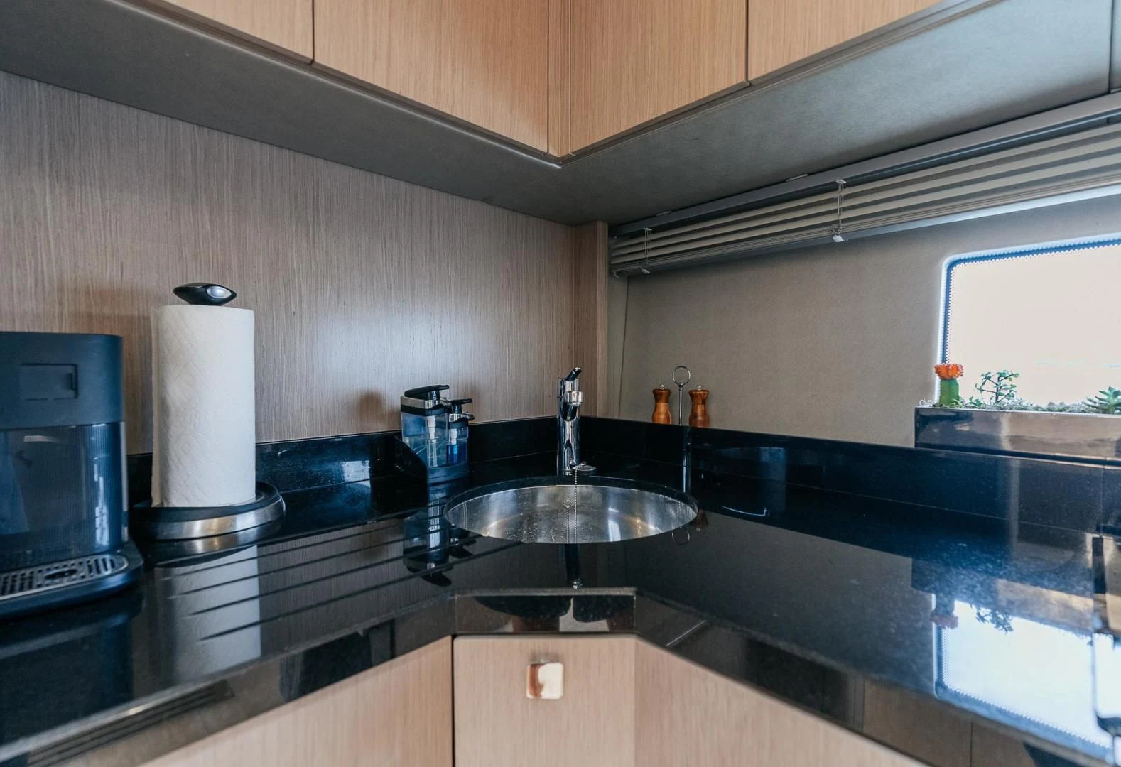 a kitchen with a sink and a window aboard GRAVITAS Yacht for Charter