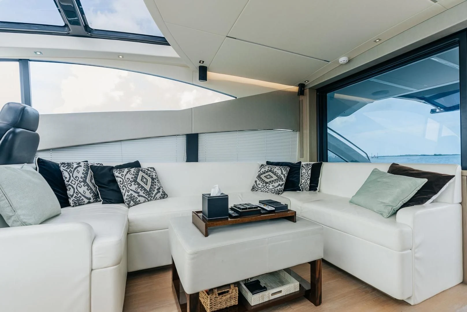 a white couch and a coffee table in a room with a large window aboard GRAVITAS Yacht for Charter