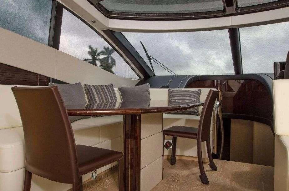a table with chairs and a window aboard GRAVITAS Yacht for Charter