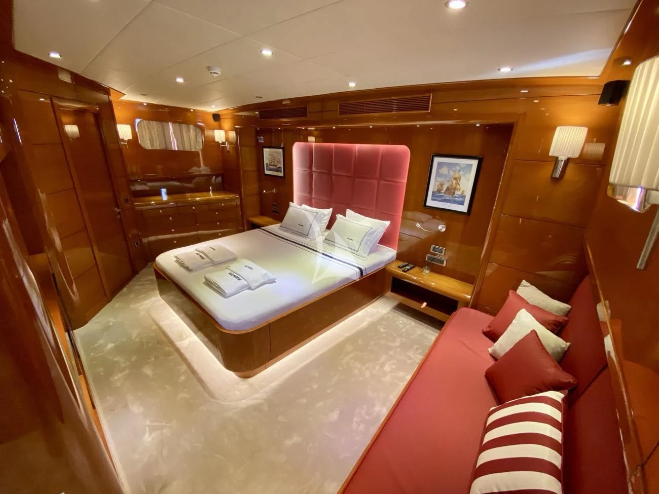 a hotel room with a bed and a red couch aboard CANARIA Yacht for Sale