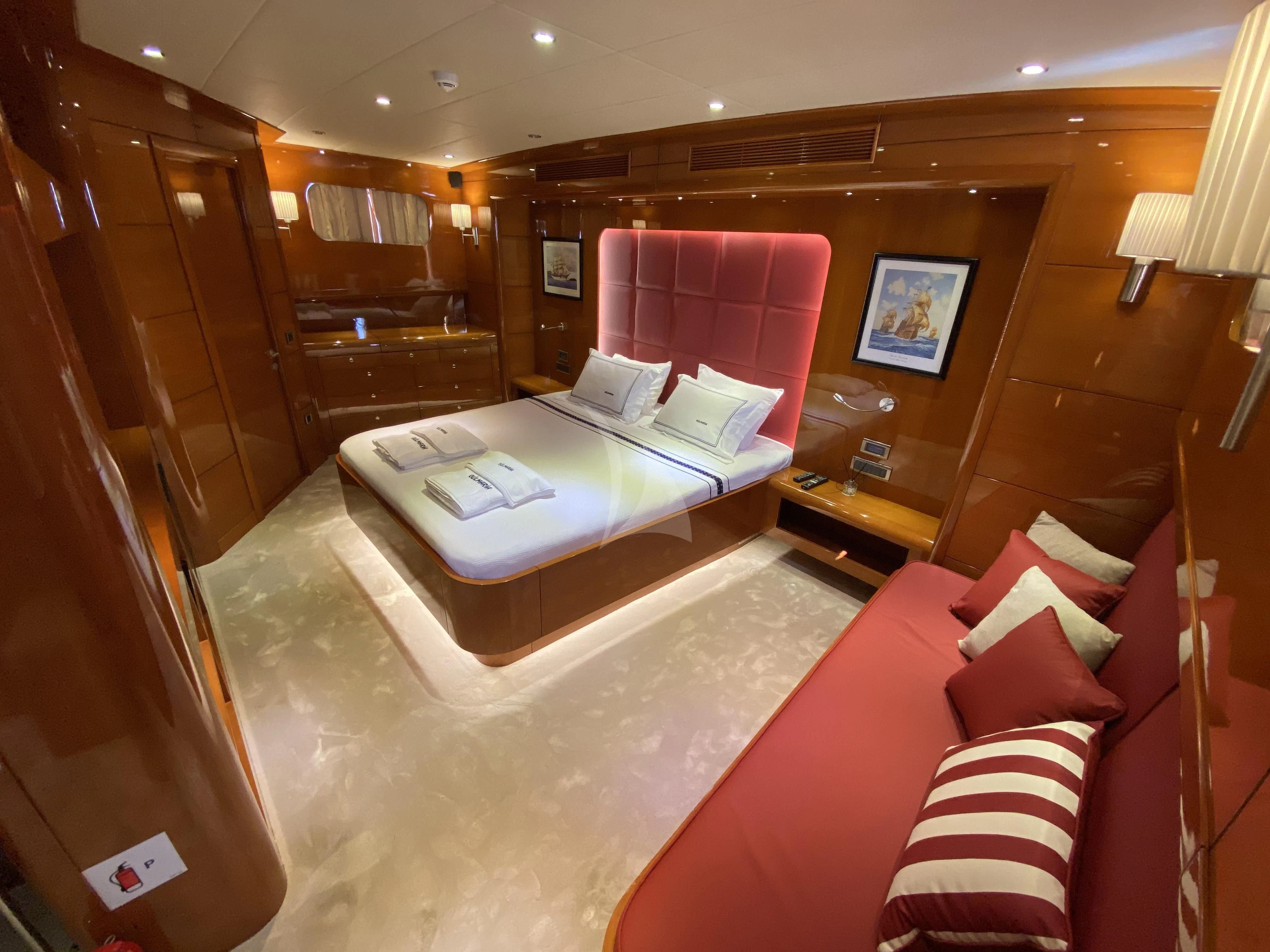 a hotel room with a bed and a red couch aboard CANARIA Yacht for Sale
