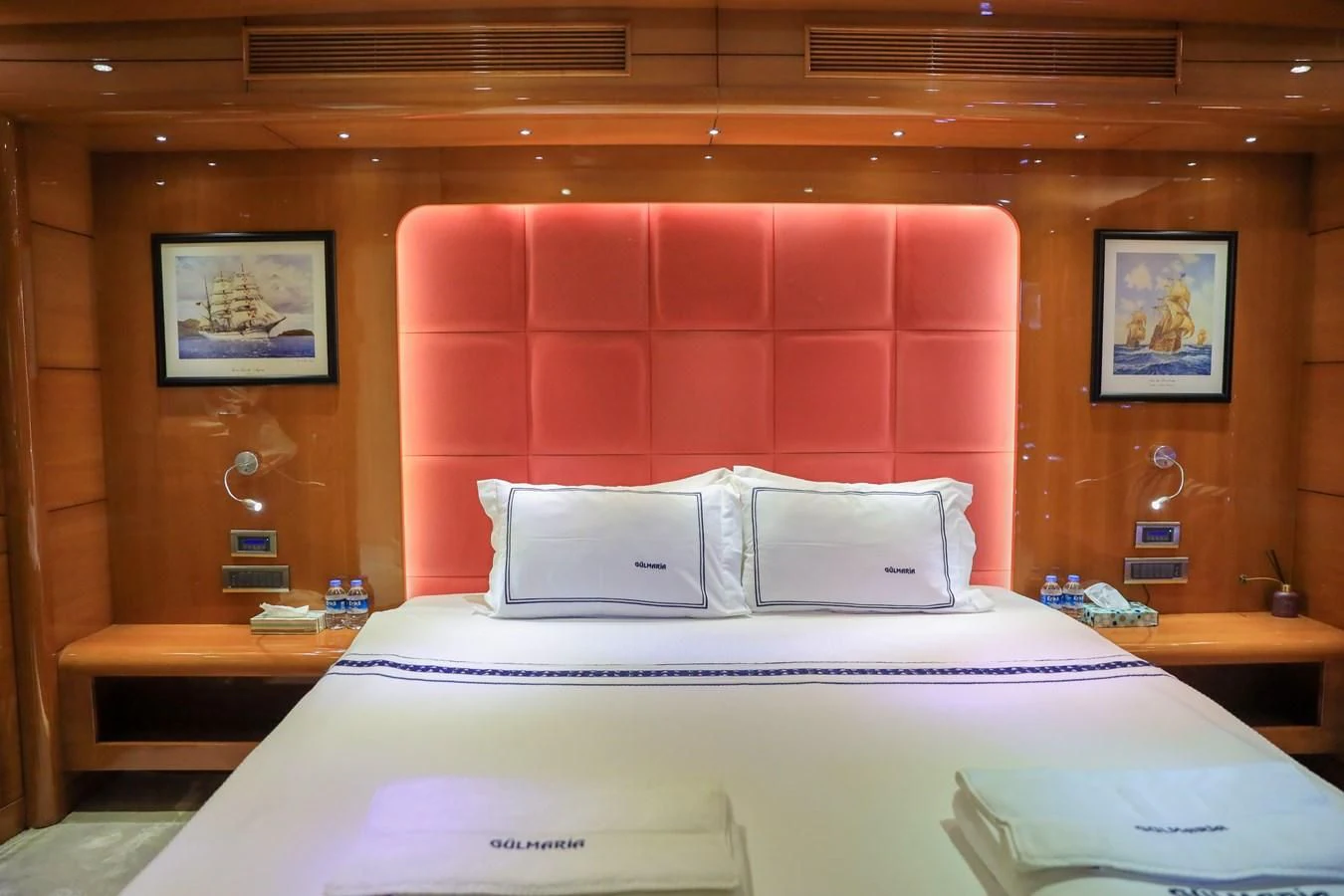 a bed with a red wall aboard CANARIA Yacht for Sale