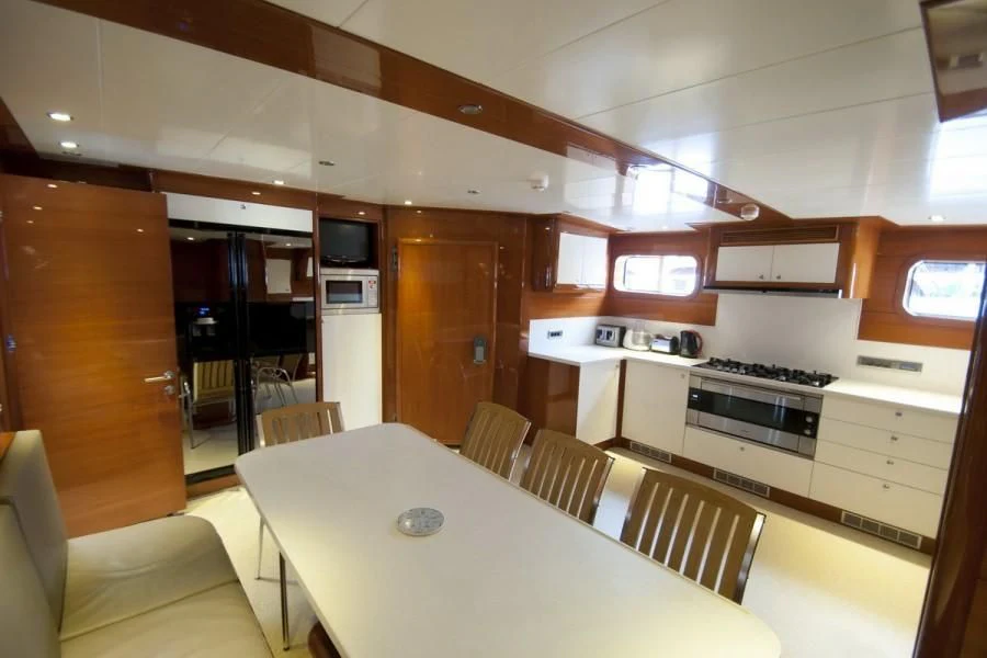 a kitchen with a dining table aboard CANARIA Yacht for Sale