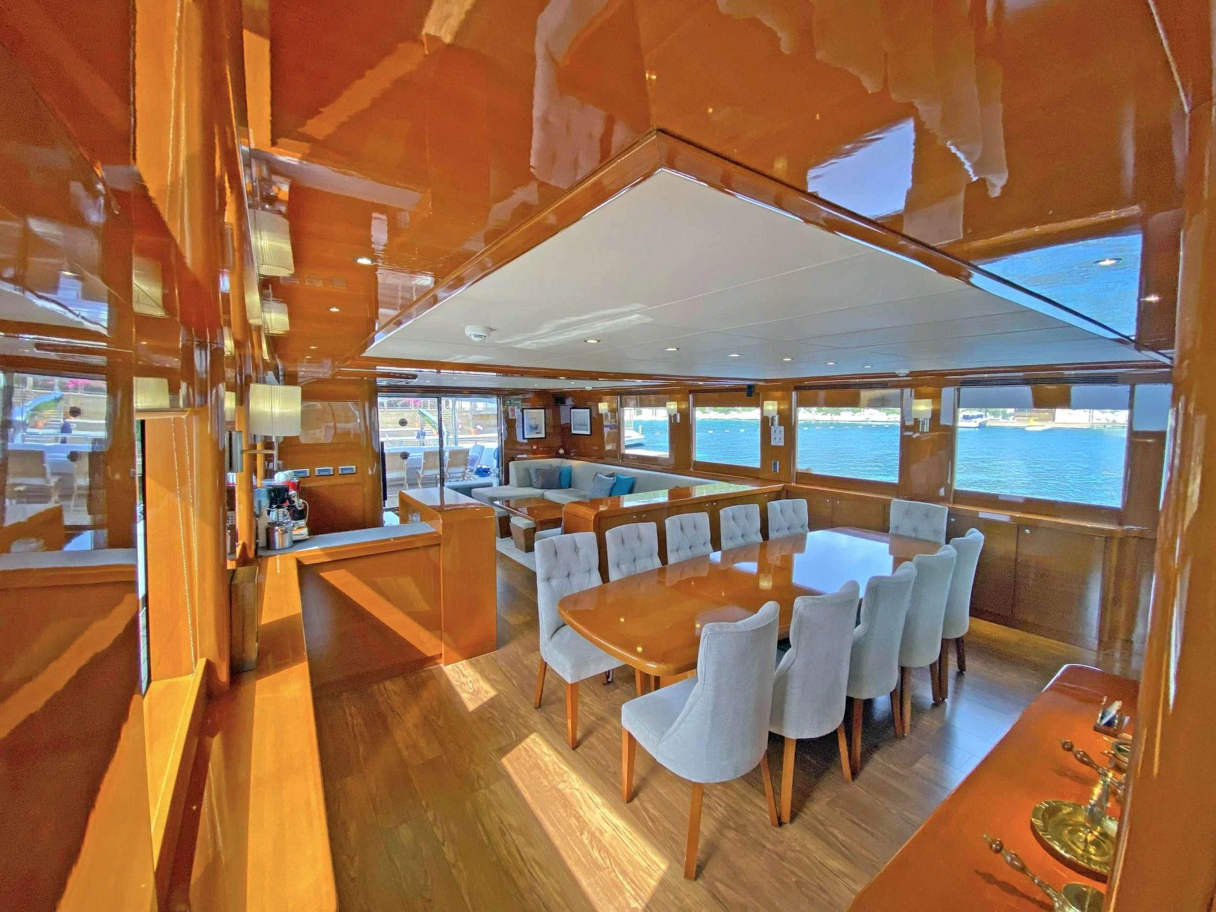 a room with tables and chairs aboard CANARIA Yacht for Sale