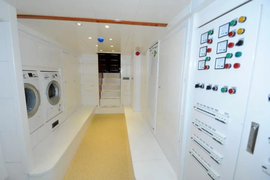 a hallway with white cabinets and a washing machine aboard CANARIA Yacht for Sale