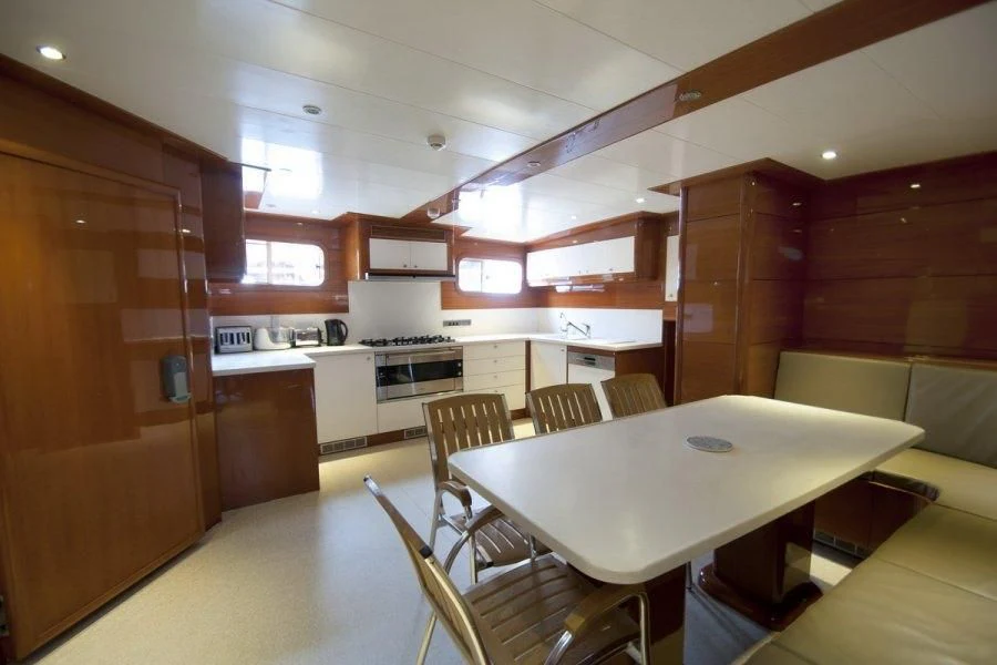a kitchen with a table and chairs aboard CANARIA Yacht for Sale