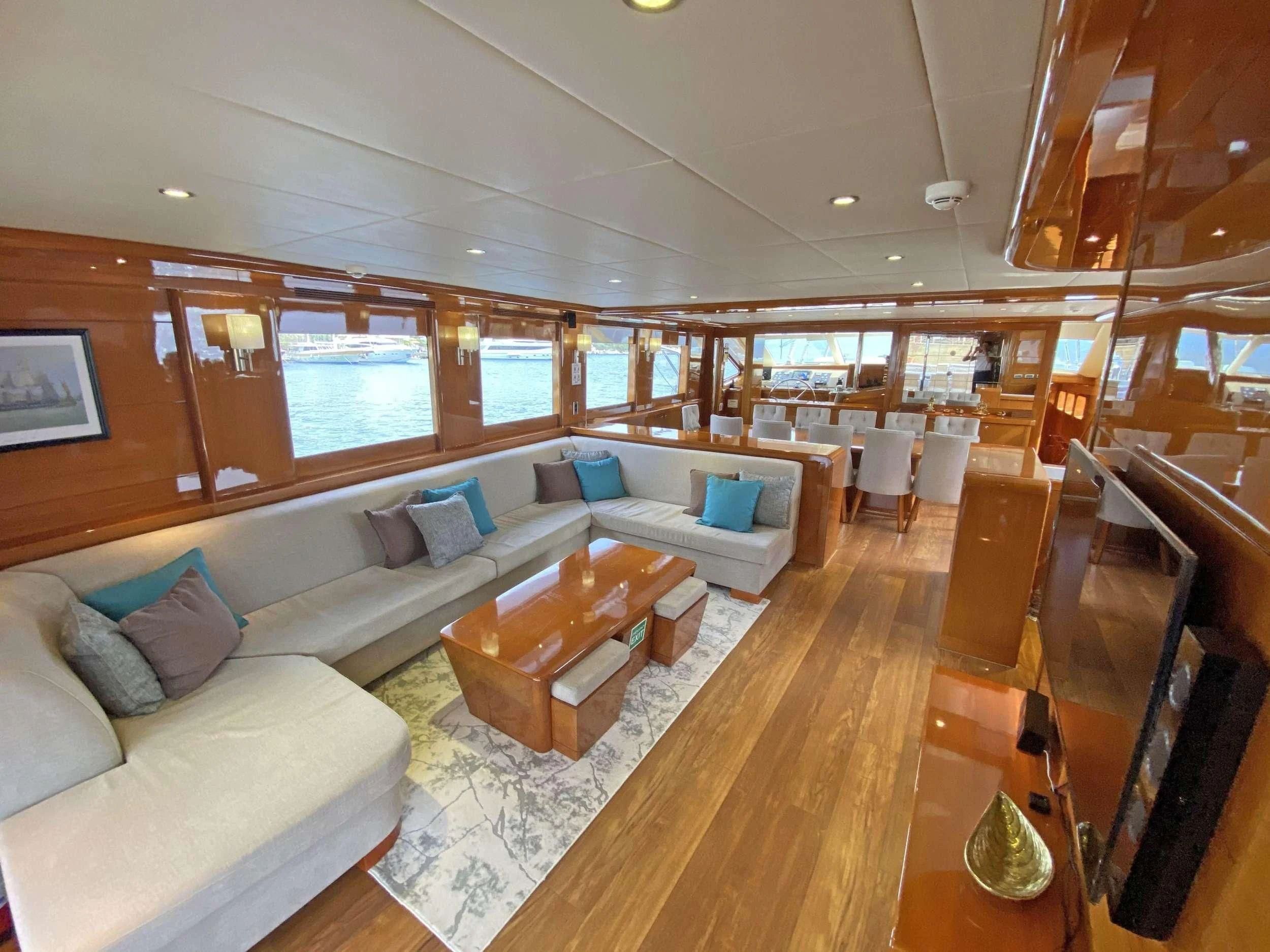 a living room with a large wood floor aboard CANARIA Yacht for Sale