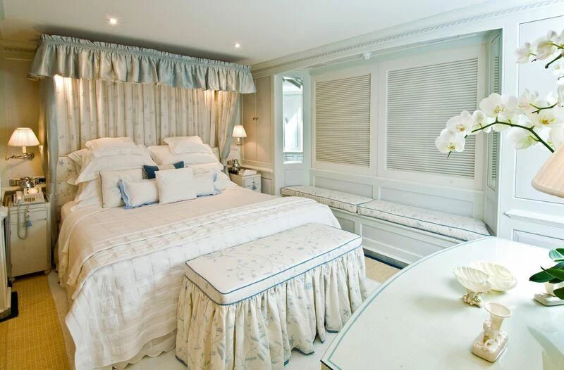 a bedroom with a bed and a table aboard VIRGINIAN Yacht for Sale