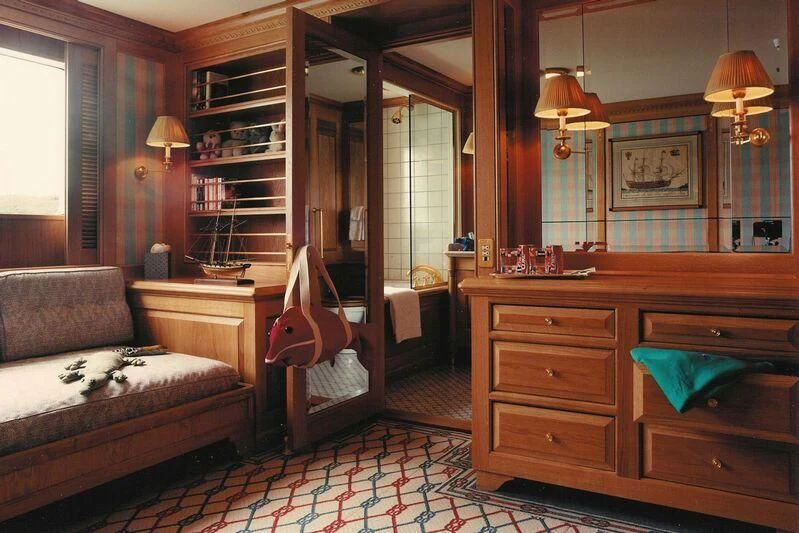 a bedroom with a bed and a bookcase aboard VIRGINIAN Yacht for Sale