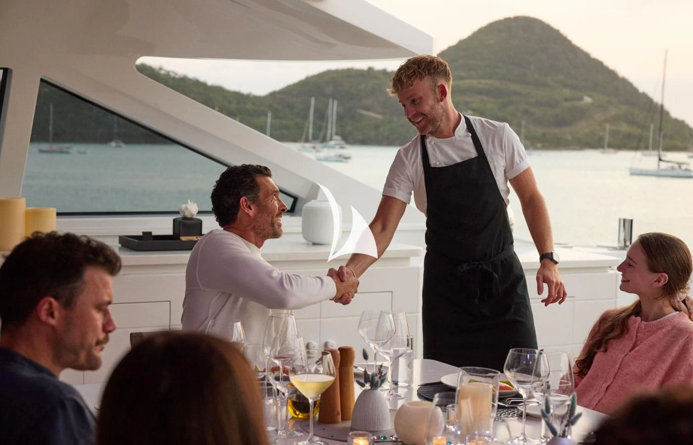 a person pouring wine into a glass aboard ARBEMA Yacht for Sale