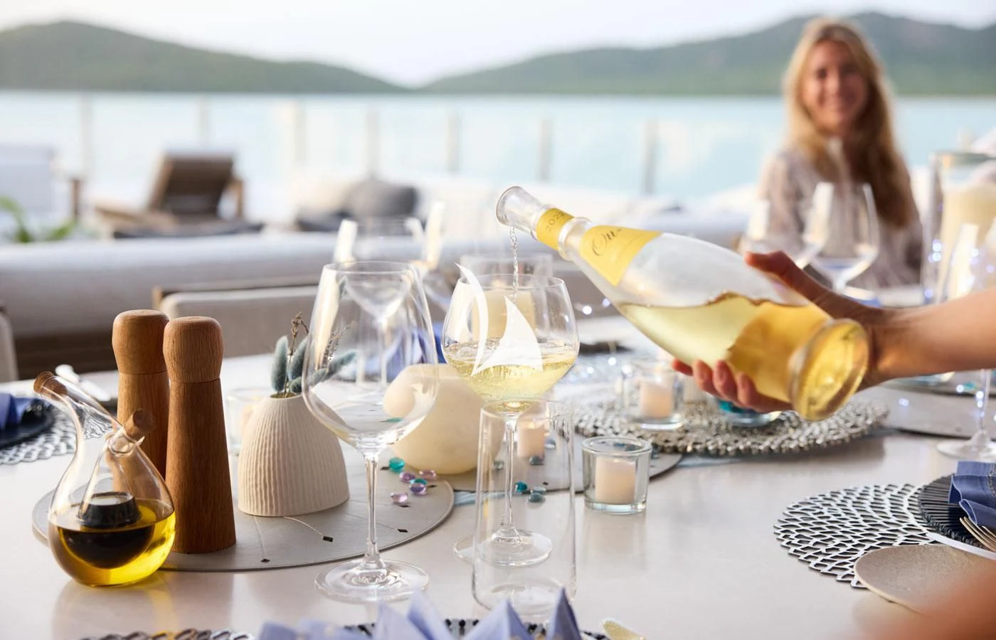 a woman pouring wine into a glass aboard ARBEMA Yacht for Sale