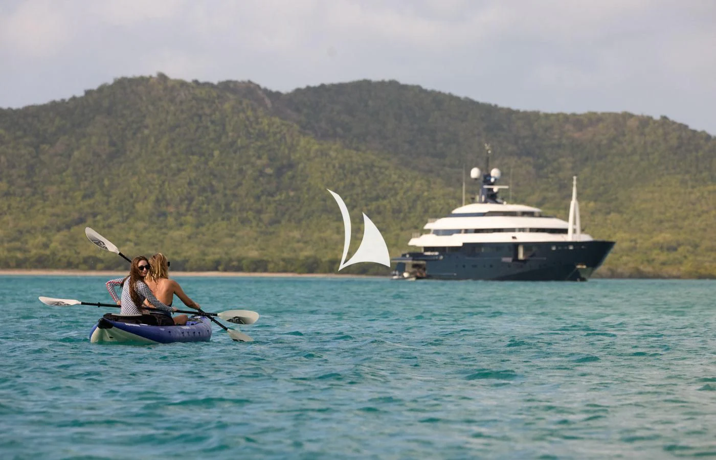 a man on a paddle boat in the water with a boat in the background aboard ARBEMA Yacht for Sale