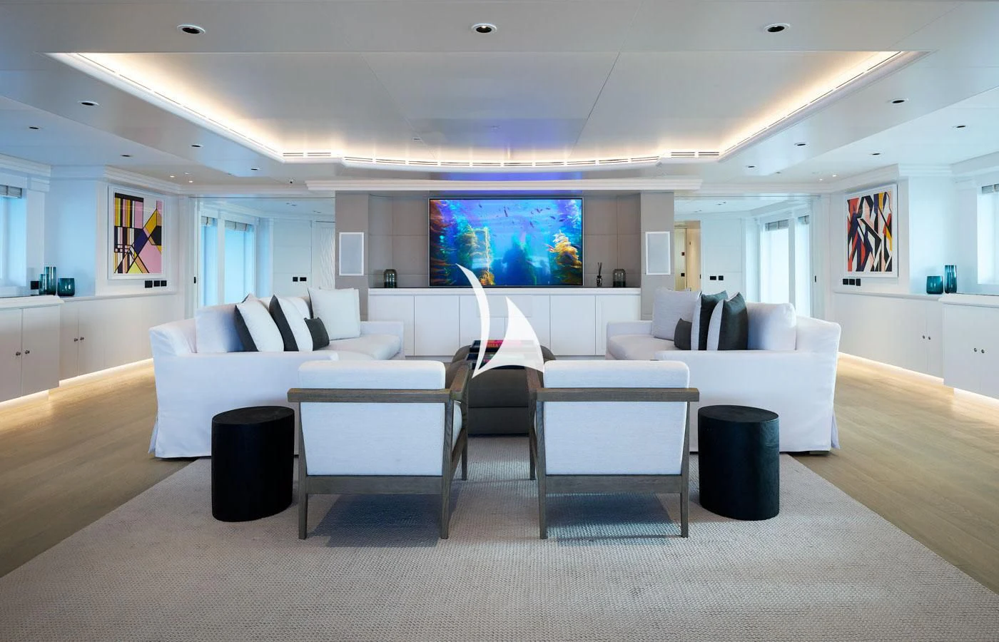a large living room with white couches and a large screen aboard ARBEMA Yacht for Sale