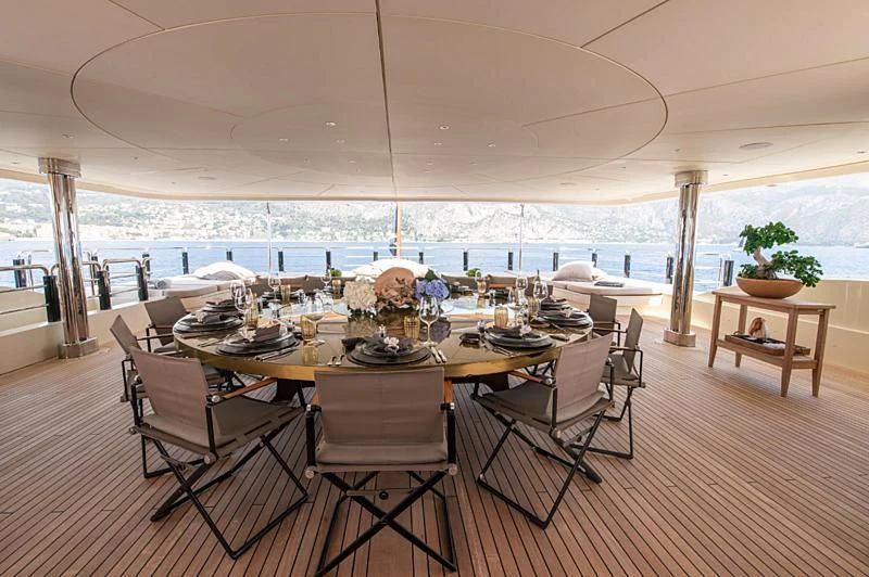 a dining table with chairs and a large window overlooking a large body of water aboard ARBEMA Yacht for Sale