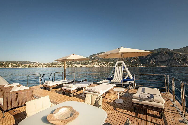 a lounge area with lounge chairs and umbrellas on a sunny day aboard ARBEMA Yacht for Sale