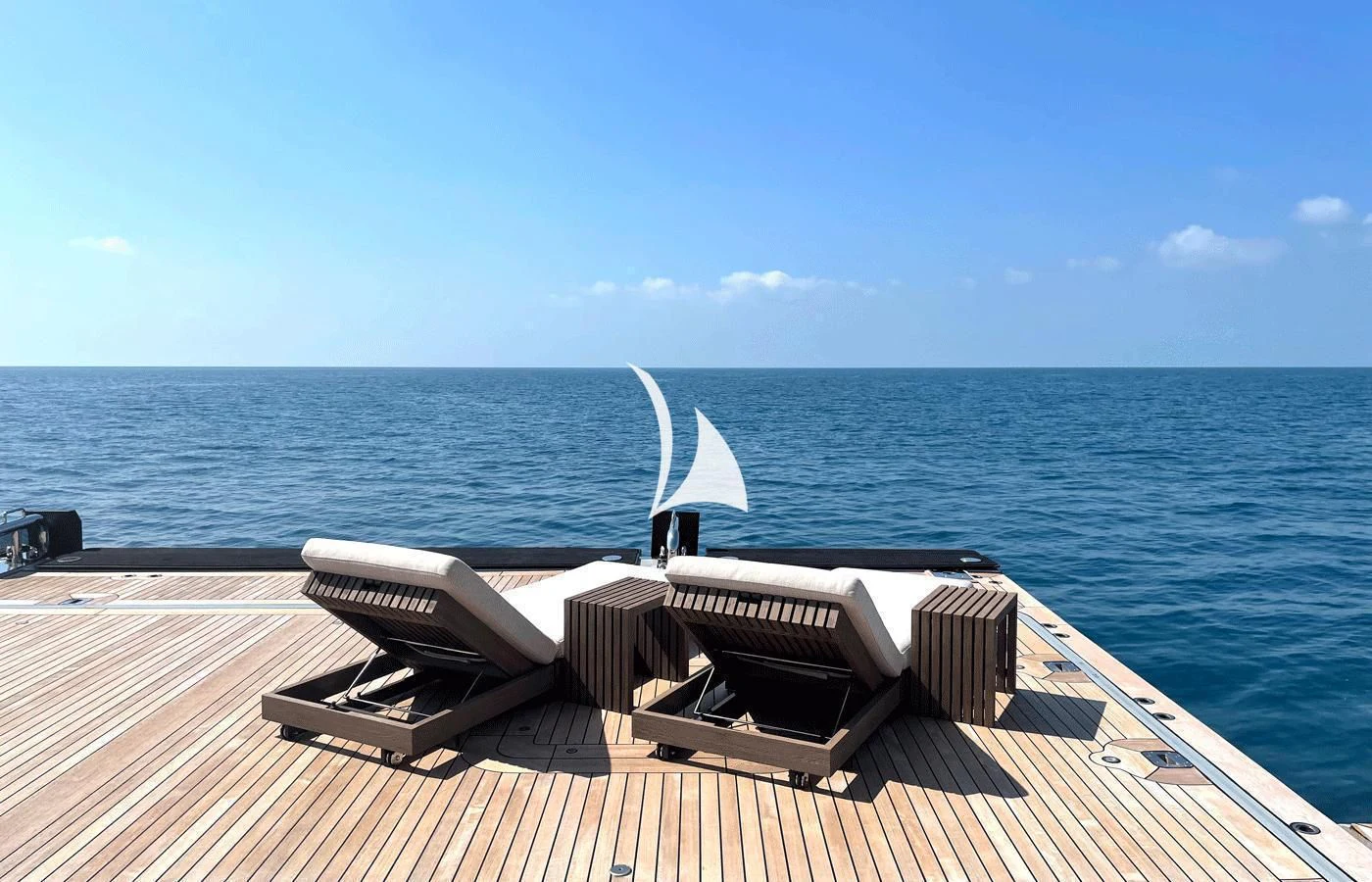 a deck with a laptop and a book on it by the water aboard ARBEMA Yacht for Sale