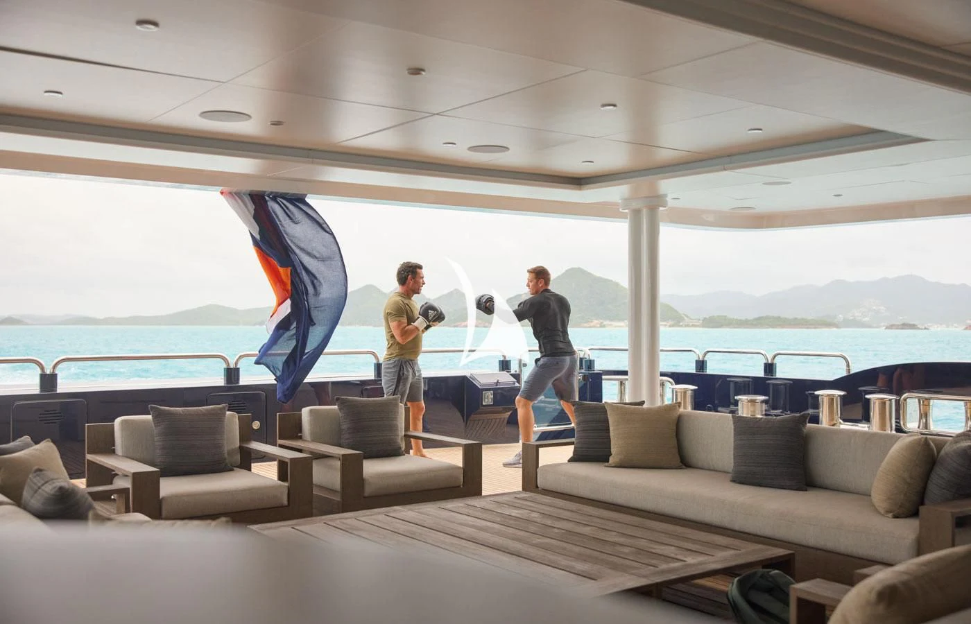 a couple of men standing on a boat with a large blue and white umbrella aboard ARBEMA Yacht for Sale