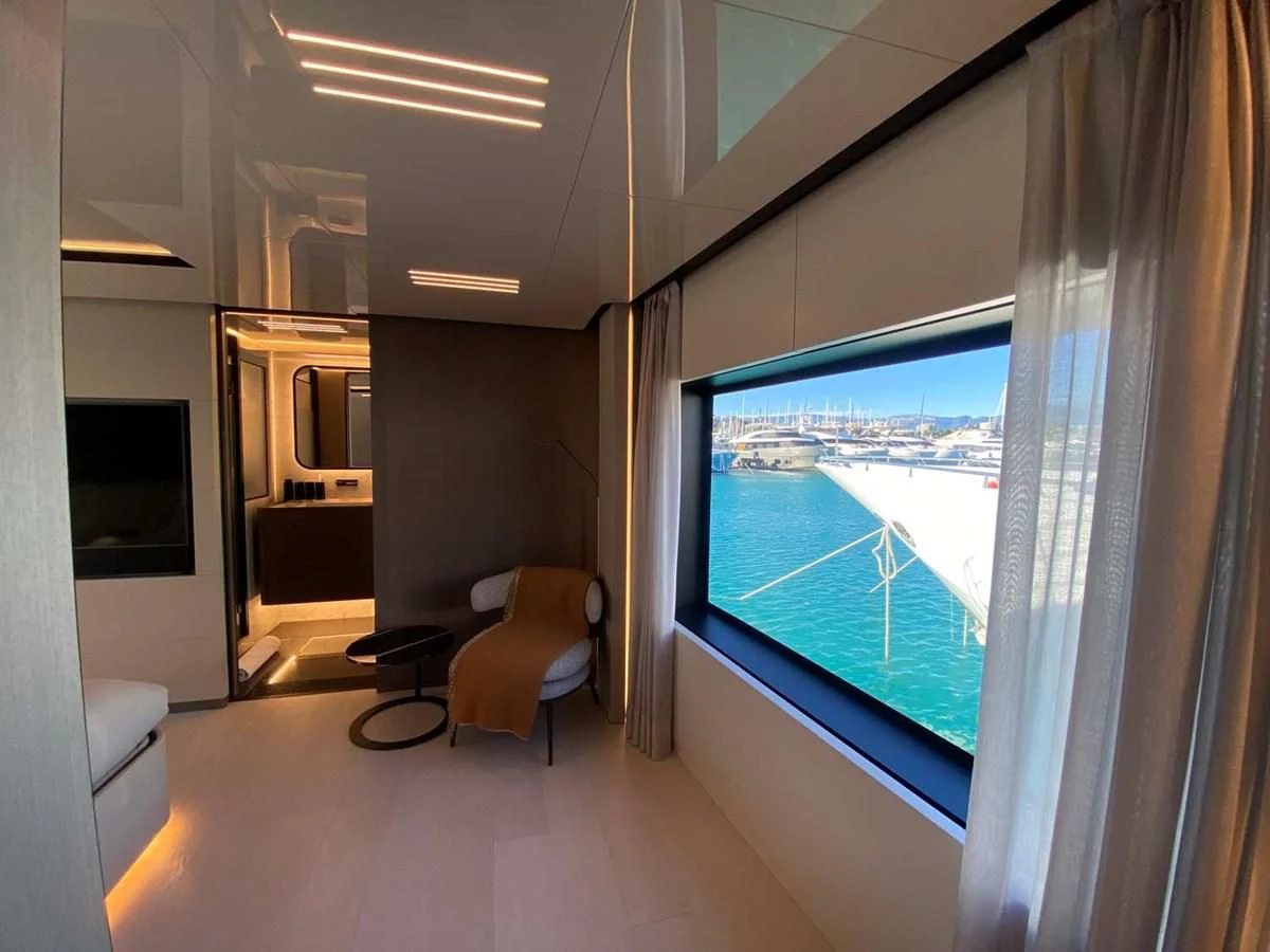 a room with a window and a view of the city aboard AMORES Yacht for Sale