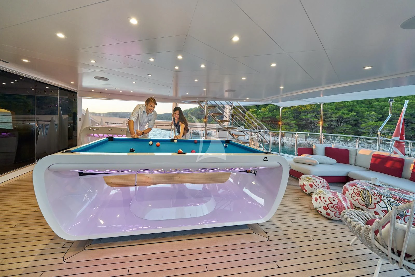 a couple of people sitting at a pool table aboard HAPPY ME Yacht for Charter