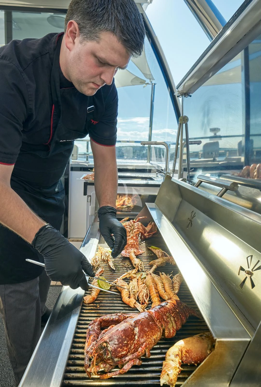 a man preparing food in a kitchen aboard HAPPY ME Yacht for Charter