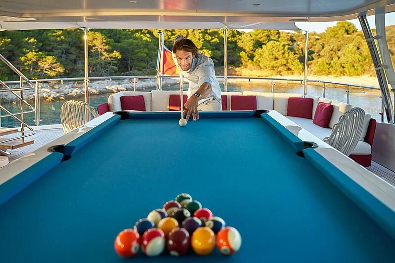 a person playing pool aboard HAPPY ME Yacht for Charter