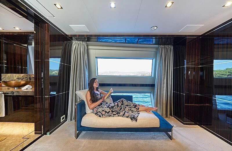 a person sitting on a couch reading a book aboard HAPPY ME Yacht for Charter