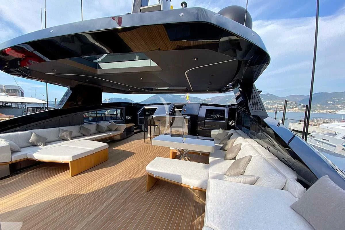 a deck with a large boat on it and a large ship in the background aboard PANAM Yacht for Sale