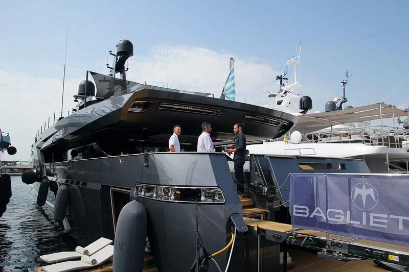 a couple of men standing on a boat in the water aboard PANAM Yacht for Sale