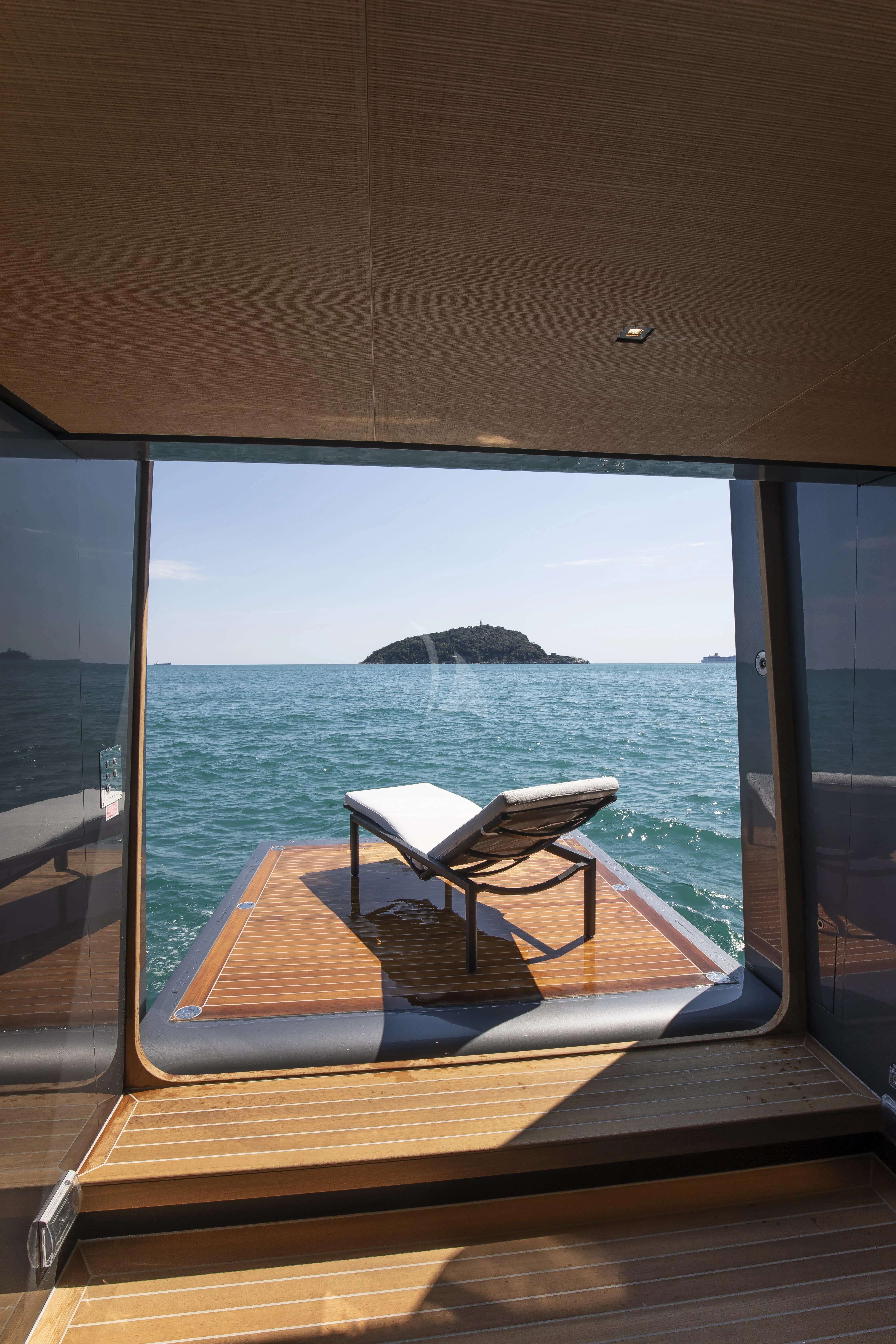 a room with a view of the ocean and a large rock formation aboard PANAM Yacht for Sale
