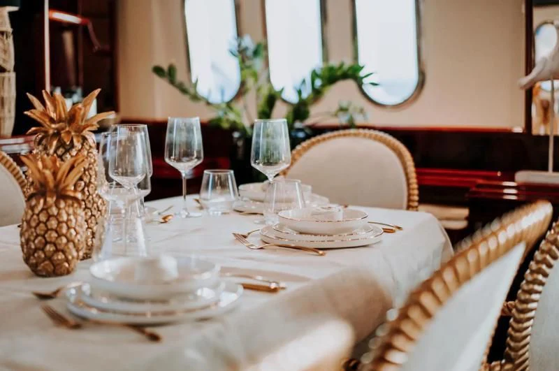 a table set with plates and glasses aboard SONRISA SEPTIMO Yacht for Sale