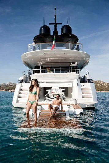 a person and a boy standing on a dock in front of a large boat aboard MAXIMUS Yacht for Sale