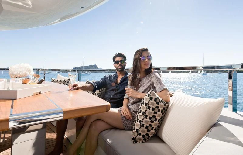 a man and woman sitting on a couch on a boat aboard MAXIMUS Yacht for Sale