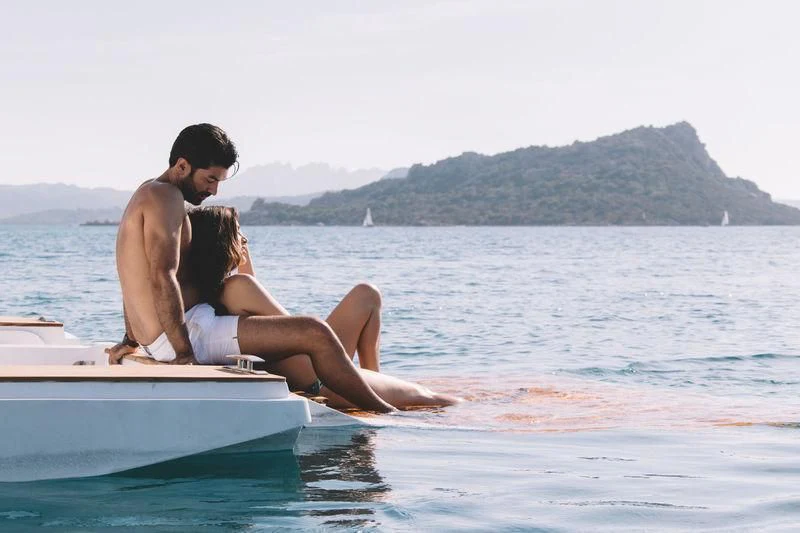 a man and woman sitting on a boat in the water aboard MAXIMUS Yacht for Sale
