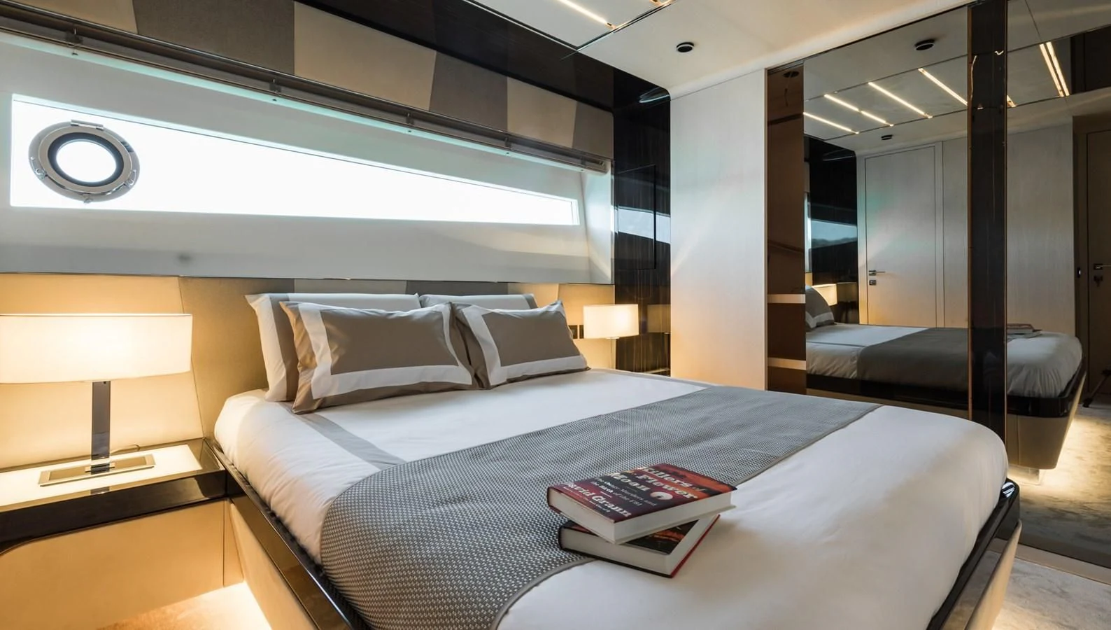 a bed with a book on it aboard MAXIMUS Yacht for Sale