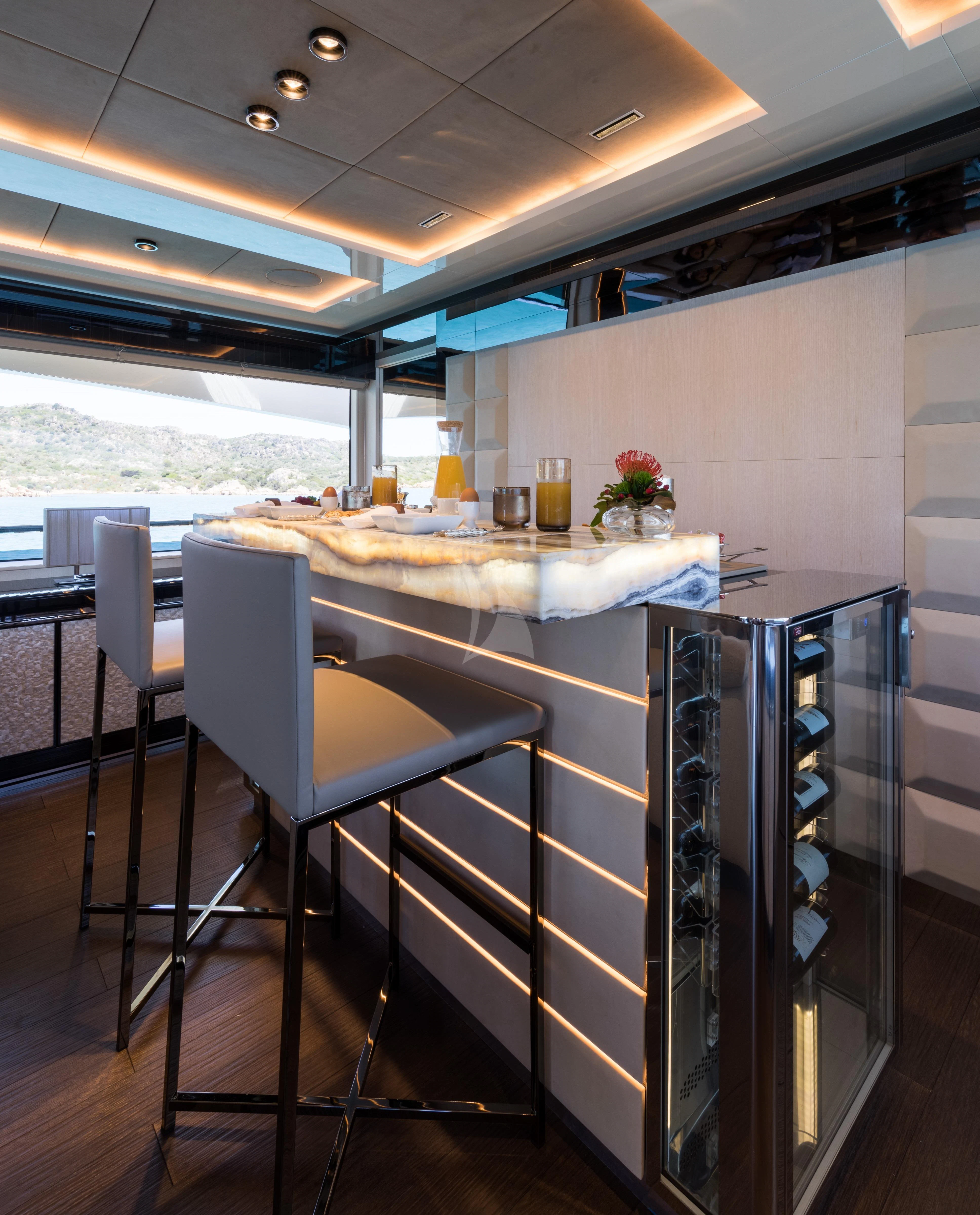 a kitchen with a bar and a table aboard MAXIMUS Yacht for Sale