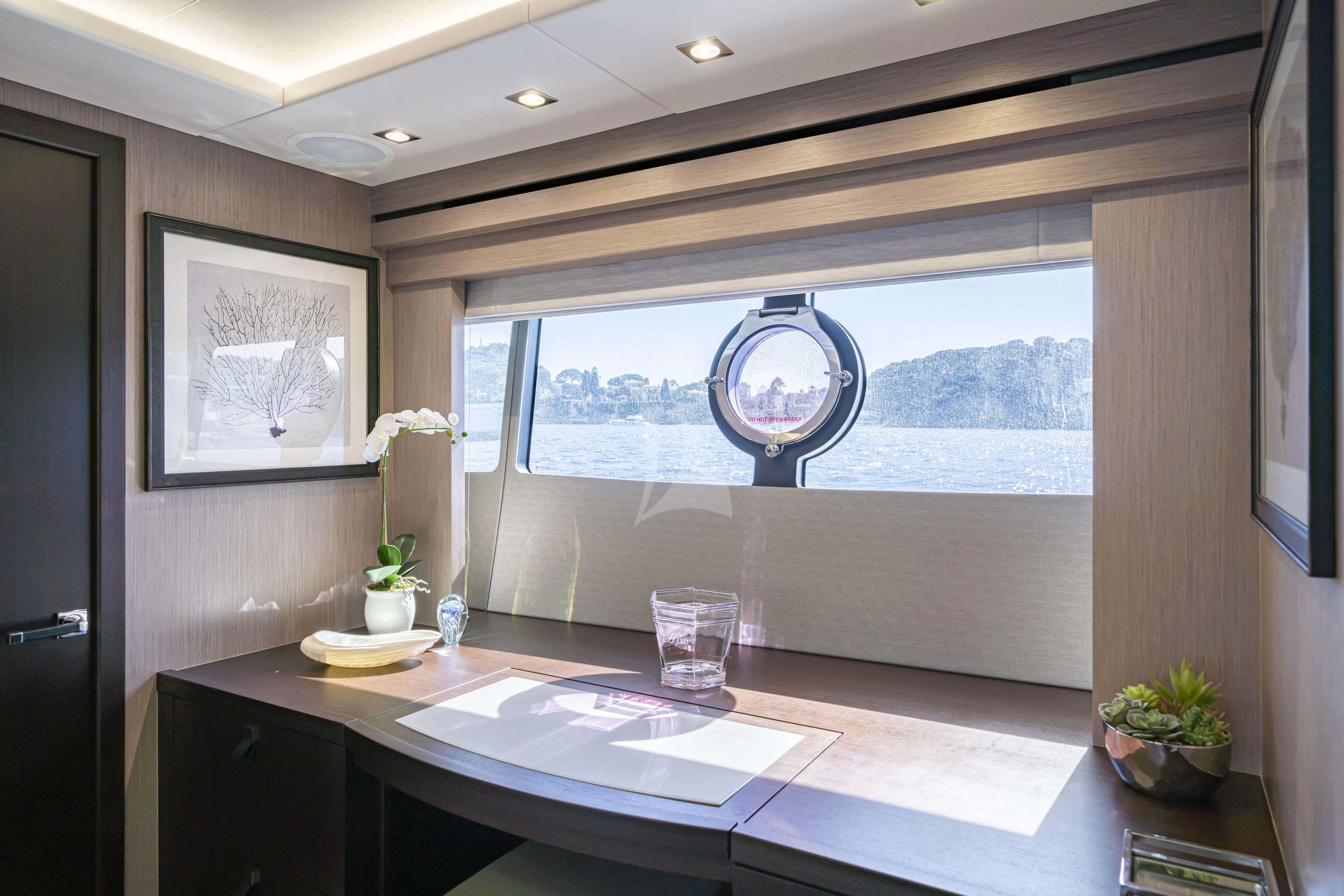 a room with a large window and a table with a view of the mountains aboard TORO Yacht for Sale