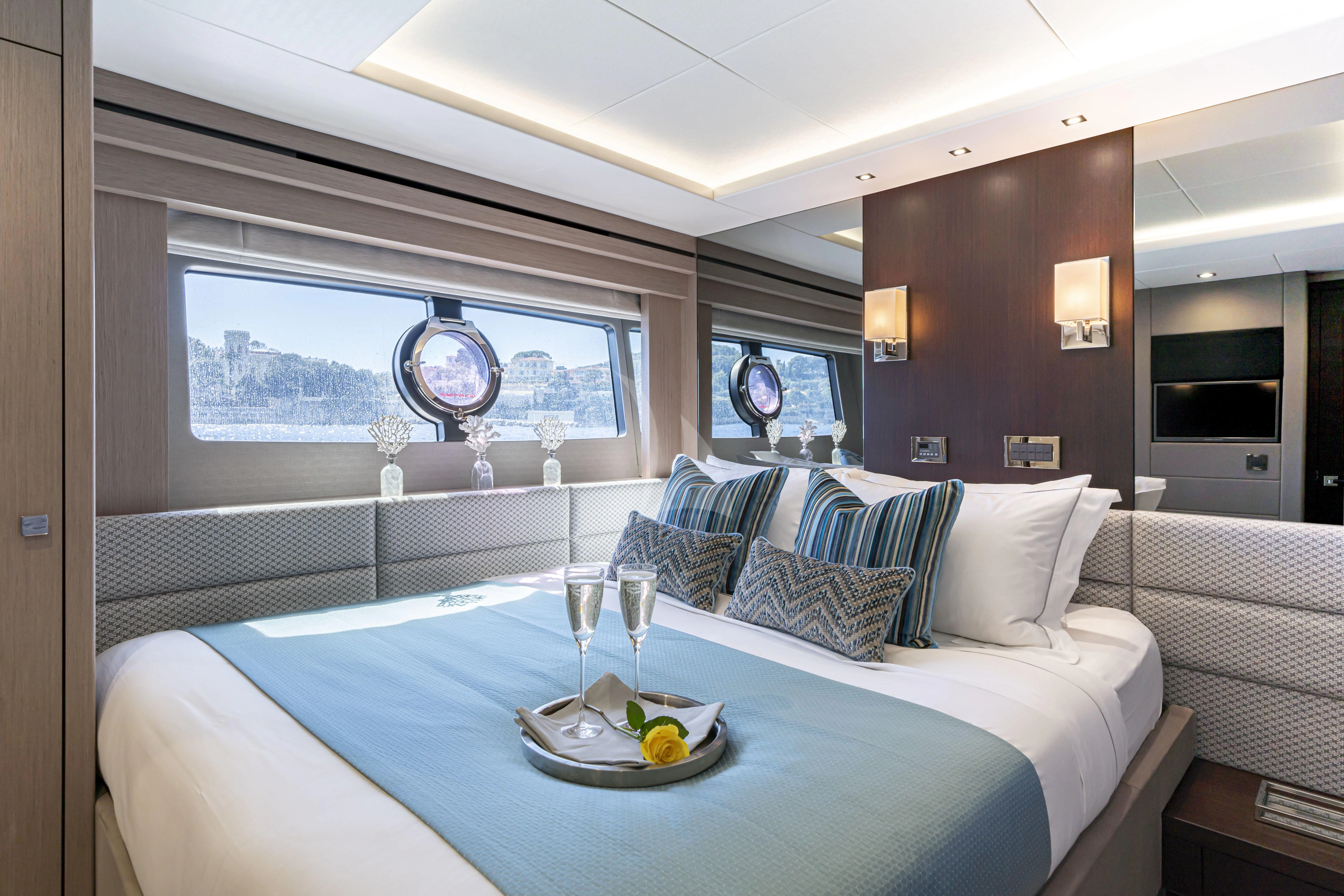 a large bedroom with a large blue table and white bedding aboard TORO Yacht for Sale