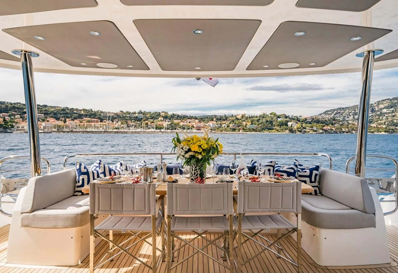 a table set for a meal on a deck overlooking a city aboard TORO Yacht for Sale