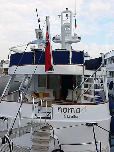 a boat with a flag on the front aboard NOMAD Yacht for Sale