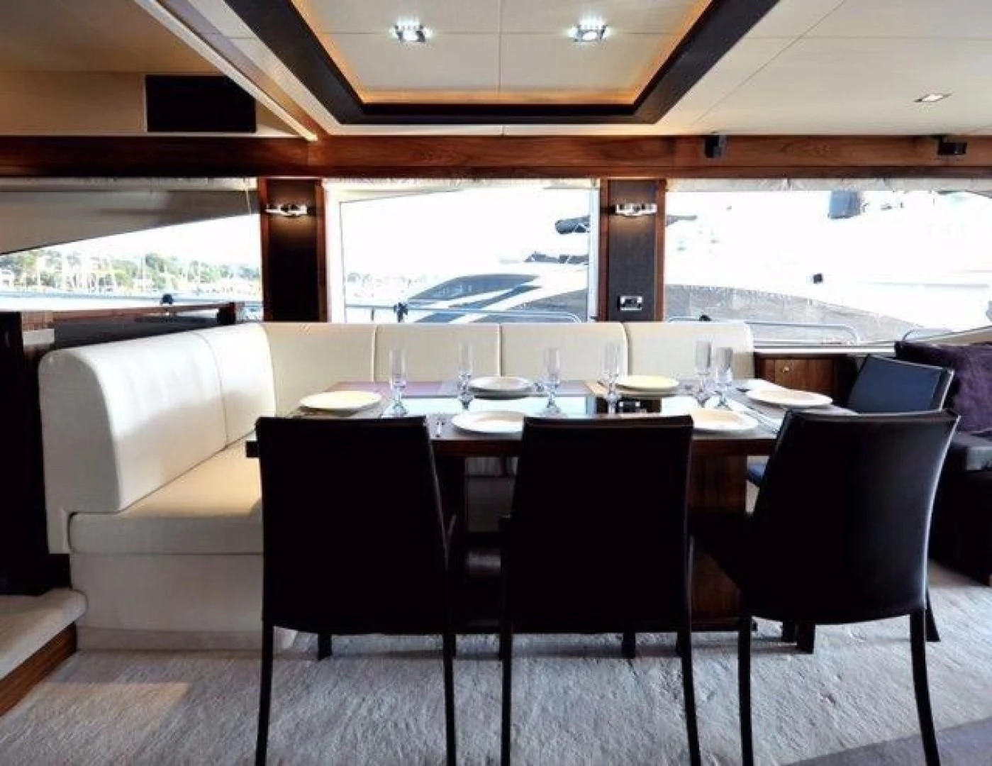 a table with chairs and a large window aboard SPLASHED OUT Yacht for Sale