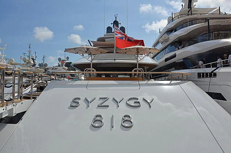 a large white boat with a red and black flag on it aboard 818 Yacht for Sale
