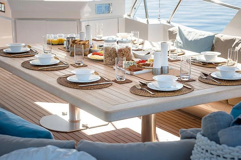 a table with food and glasses on it aboard MOONRAKER II Yacht for Sale